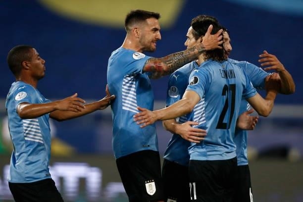 Edinson Cavani of Uruguay celebrates with teammates after scoring the first goal of his team during a group A match between Uruguay and Paraguay as...