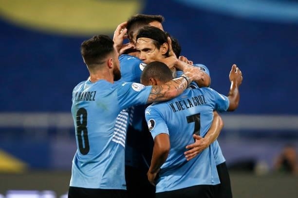 Edinson Cavani of Uruguay celebrates with teammates Nahitan Nandez and Nicolas De La Cruz after scoring the first goal of his team during a group A...