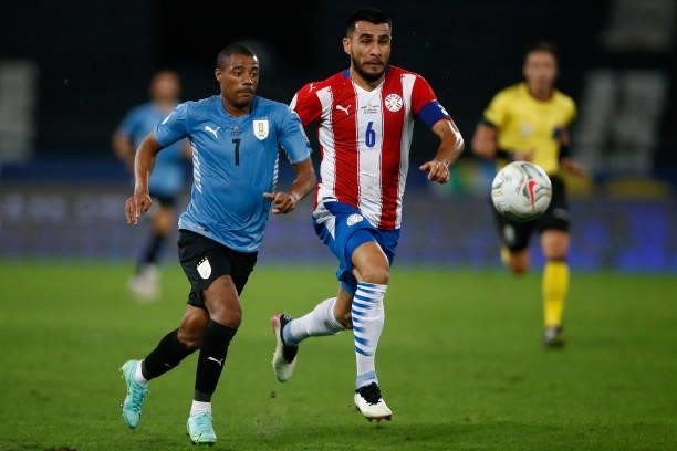 Nicolas De La Cruz of Uruguay competes for the ball with Junior Alonso of Paraguay during a group A match between Uruguay and Paraguay as part of...