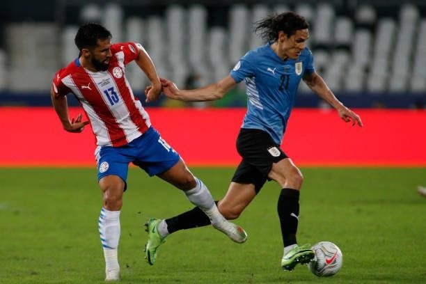 Alberto Espinola of Paraguay competes for the ball with Edinson Cavani of Uruguay during a group A match between Uruguay and Paraguay as part of...