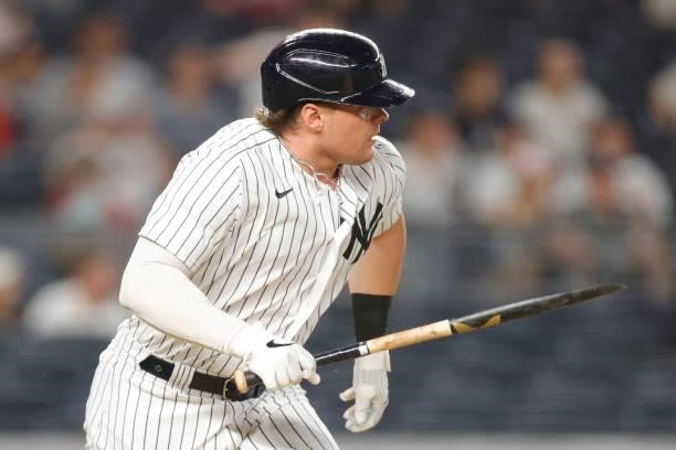 Luke Voit of the New York Yankees carries his broken bat as he runs to first after grounding out during the sixth inning against the Los Angeles...