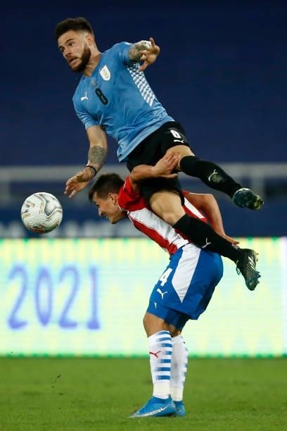 Adrian Cubas of Paraguay competes for the ball with Nahitan Nandez of Uruguay during a group A match between Uruguay and Paraguay as part of Conmebol...