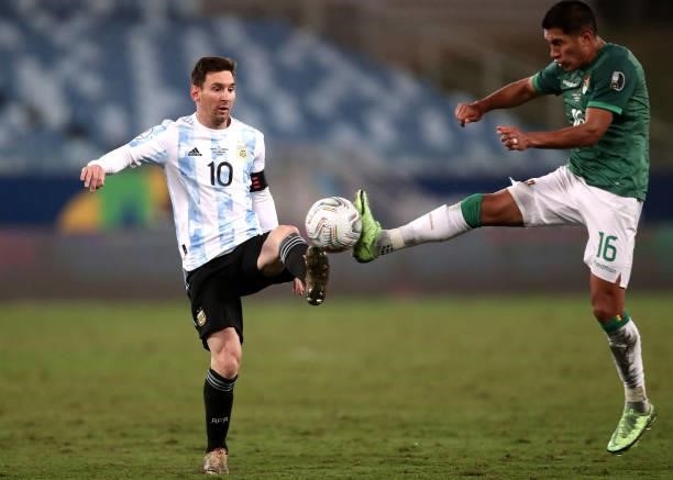 Lionel Messi of Argentina fights for the ball with Erwin Saavedra of Bolivia during a Group A match between Argentina and Bolivia as part of Copa...