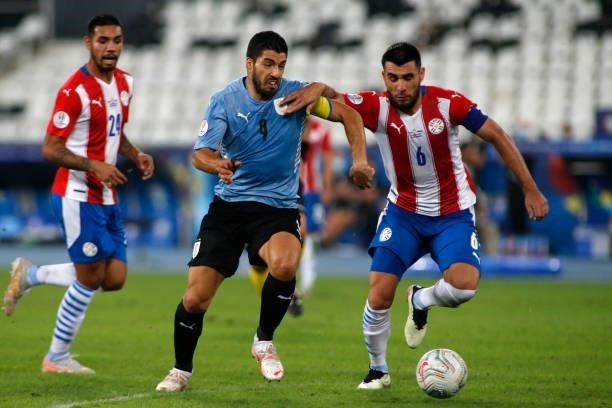 Luis Suarez of Uruguay competes for the ball with Junior Alonso of Paraguay during a group A match between Uruguay and Paraguay as part of Conmebol...