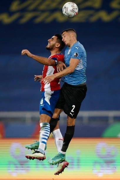 Junior Alonso of Paraguay jumps for the ball with Jose Gimenez of Uruguay during a group A match between Uruguay and Paraguay as part of Conmebol...