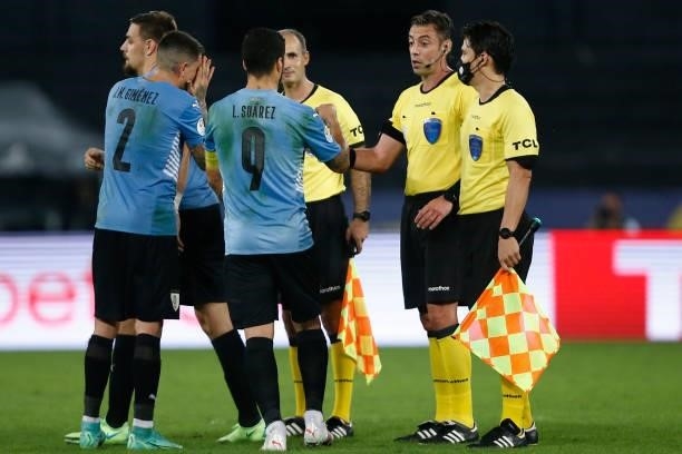 Jose Gimenez and Luis Suarez of Uruguay greet referee Raphael Claus after a group A match between Uruguay and Paraguay as part of Conmebol Copa...