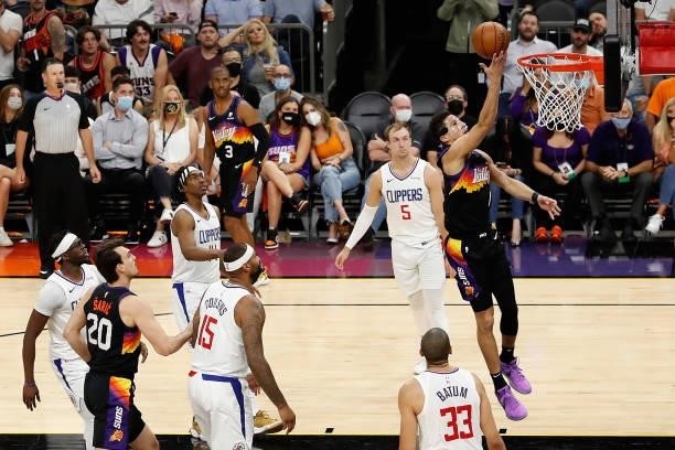 Devin Booker of the Phoenix Suns lays up a shot past Luke Kennard of the LA Clippers during the second half of game five of the Western Conference...