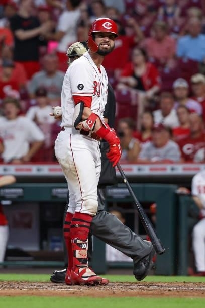 Jesse Winker of the Cincinnati Reds reacts after being hit by a pitch in the seventh inning against the Philadelphia Phillies at Great American Ball...