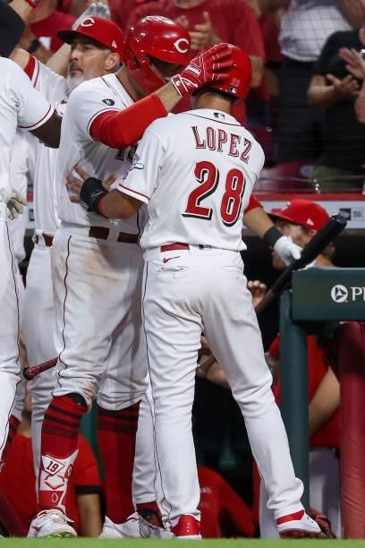 Joey Votto and Alejo Lopez of the Cincinnati Reds celebrate after Lopez scored a run in the seventh inning against the Philadelphia Phillies at Great...