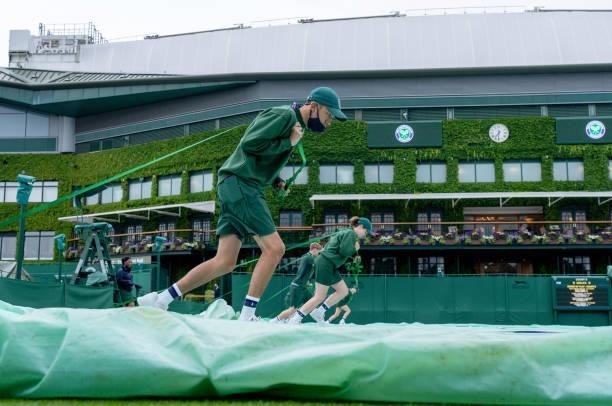 Court Coverers in action on the southern outside courts during Day Two of The Championships - Wimbledon 2021 at All England Lawn Tennis and Croquet...