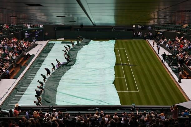 Ground Staff remove the rain cover on court one during the Men's Singles First Round match between Tallon Griekspoor of Netherlands and Alexander...