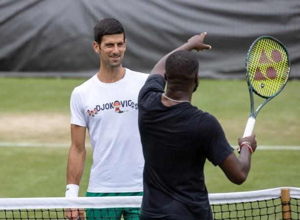 Novak Djokovic of Serbia practices with Frances Tiafoe of United States on the Aorangi Practice Courts during Day Two of The Championships -...