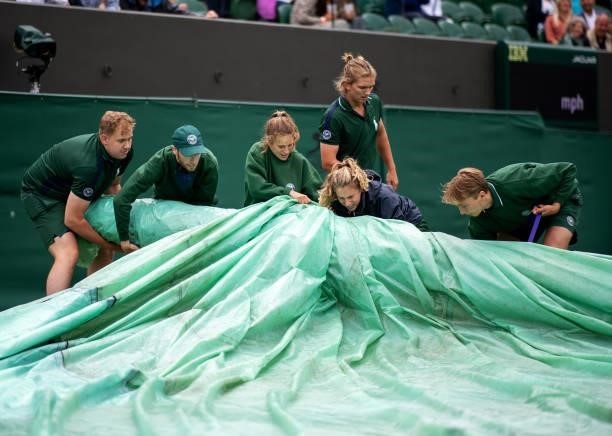 Court Coverers in action on No.2 Court as the rain falls during Day Two of The Championships - Wimbledon 2021 at All England Lawn Tennis and Croquet...