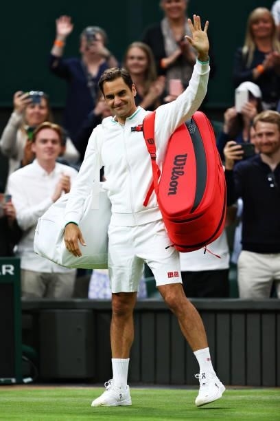 Roger Federer of Switzerland waves to the fans as he walks off the court after his opponent Adrian Mannarino of France retired from the match with an...