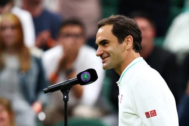 Roger Federer of Switzerland smiles as is interviewed on the court after his opponent Adrian Mannarino of France retired from the match with an...