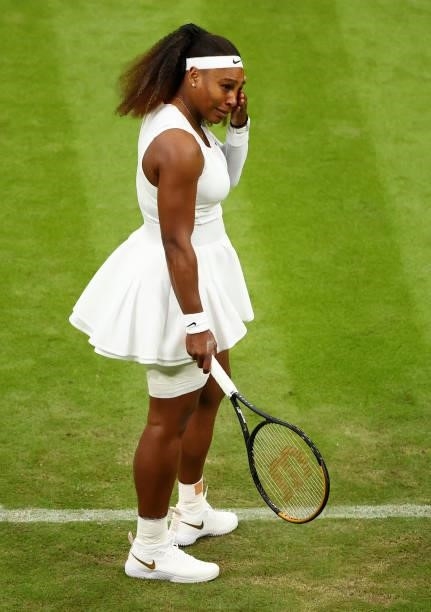 Serena Williams of The United States reacts in pain as she prepares to serve in her Ladies' Singles First Round match against Aliaksandra Sasnovich...