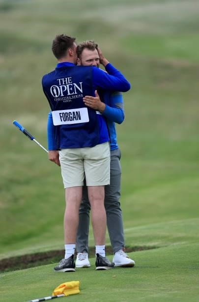 Sam Forgan of England is embraced by his brother Jack Forgan after holing a putt on his final hole in his second round to secure a place in the 149th...