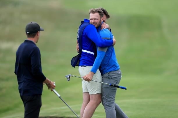 Sam Forgan of England is embraced by his brother Jack Forgan after holing a putt on his final hole in his second round to secure a place in the 149th...