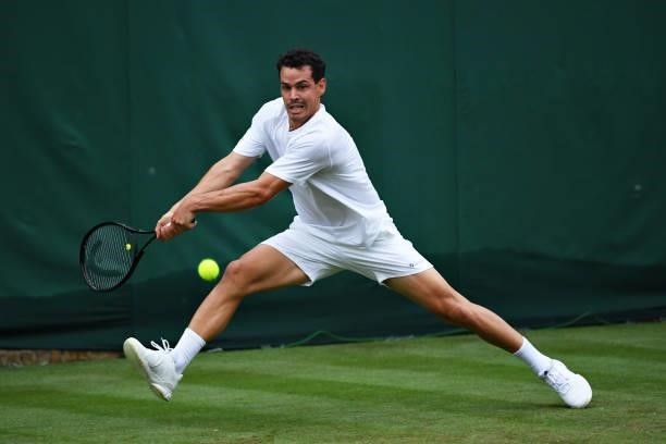 Alex Bolt of Australia stretches to plays a backhand in his Men's Singles First Round match against Filip Krajinovic of Serbia during Day Two of The...
