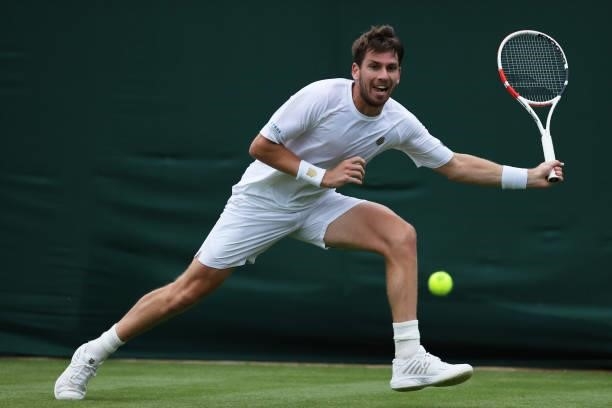 Cameron Norrie of Great Britain stretches to play a forehand in his Men's Singles First Round match against Lucas Pouille of France during Day Two of...