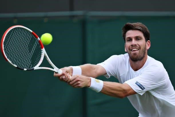 Cameron Norrie of Great Britain stretches to play a backhand in his Men's Singles First Round match against Lucas Pouille of France during Day Two of...