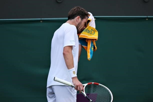 Cameron Norrie of Great Britain wipes his face with a towel in his Men's Singles First Round match against Lucas Pouille of France during Day Two of...