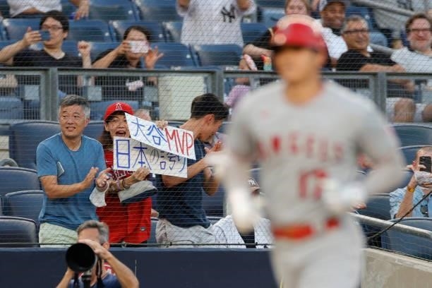 Fans react as Shohei Ohtani of the Los Angeles Angels rounds the bases after hitting a solo home run during the third inning against the New York...