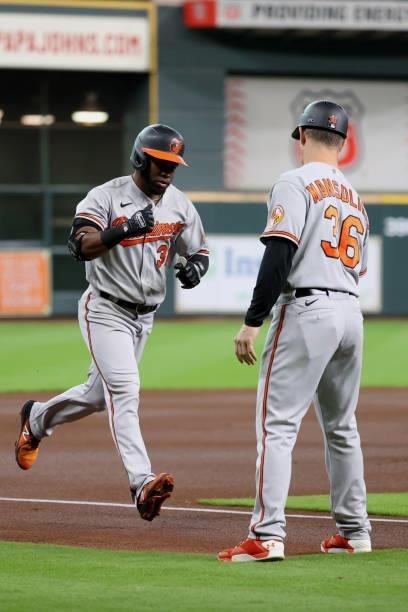 Cedric Mullins of the Baltimore Orioles high fives Tony Mansolino after hitting a home run during the first inning against the Houston Astros at...