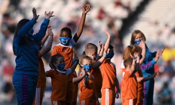 Children in smiling face coverings wave to the crowd before the UEFA Euro 2020 Championship Round of 16 match between Sweden and Ukraine at Hampden...