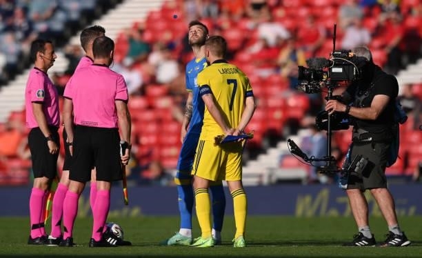 Ukraine captain Andriy Yarolenko watches the tossed coin as Sweden captain Sebastian Larsson and the match officials look on during the UEFA Euro...