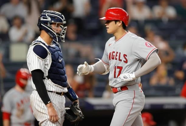 Shohei Ohtani of the Los Angeles Angels reacts after hitting a two-run home run as Gary Sanchez of the New York Yankees looks on during the fifth...