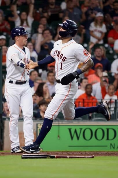 Carlos Correa of the Houston Astros high fives Myles Straw after scoring on a sacrifice fly hit by Abraham Toro during the second inning against the...