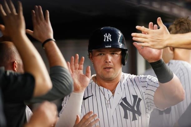 Luke Voit of the New York Yankees high-fives teammates after scoring during the fourth inning against the Los Angeles Angels at Yankee Stadium on...