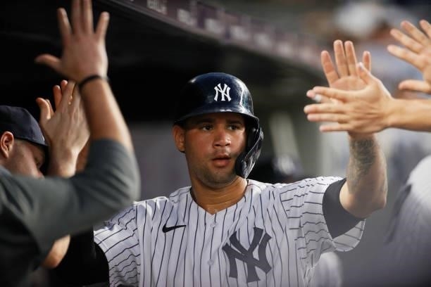 Gary Sanchez of the New York Yankees high-fives teammates after scoring on a two-RBI double hit by Luke Voit during the fourth inning against the Los...