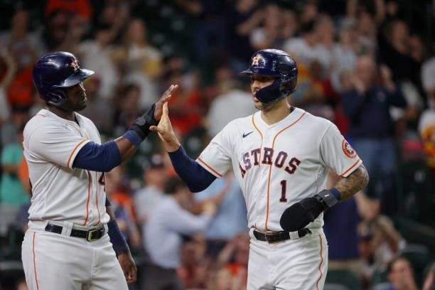 Carlos Correa of the Houston Astros and Yordan Alvarez high five after being driven in by Abraham Toro during the fifth inning against the Baltimore...