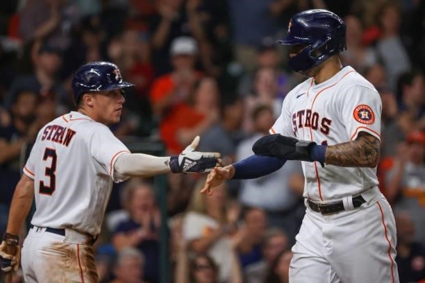 Carlos Correa of the Houston Astros and Myles Straw high five after Correa is driven in by Abraham Toro during the fifth inning against the Baltimore...
