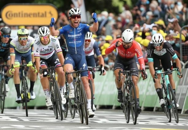 Mark Cavendish of Great Britain and Deceuninck - Quick Step celebrates winning in front of, from left, Peter Sagan of Slovakia and Team...