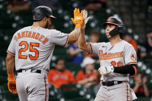 Ramon Urias of the Baltimore Orioles high fives Anthony Santander after hitting a home run during the ninth inning against the Houston Astros at...
