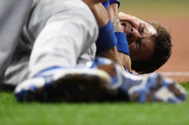 Jose Lobaton of the Chicago Cubs grimaces after suffering an injury after a collision at first base in the ninth inning against the Milwaukee Brewers...