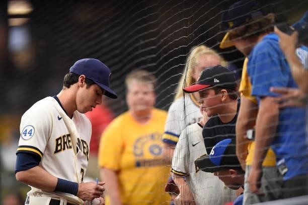 Christian Yelich of the Milwaukee Brewers signs autographs for fans before a game against the Chicago Cubs at American Family Field on June 29, 2021...
