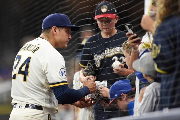 Avisail Garcia of the Milwaukee Brewers signs autographs for fans before a game against the Chicago Cubs at American Family Field on June 29, 2021 in...