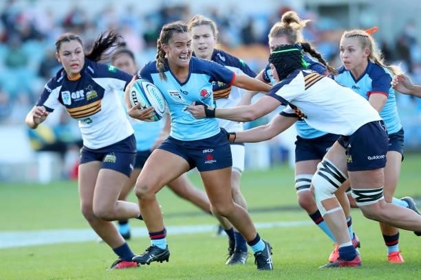 Katrina Barker of the Waratahs runs with the ball and is tackled by Michaela Leonard of the Brumbies during the round three Super W match between the...