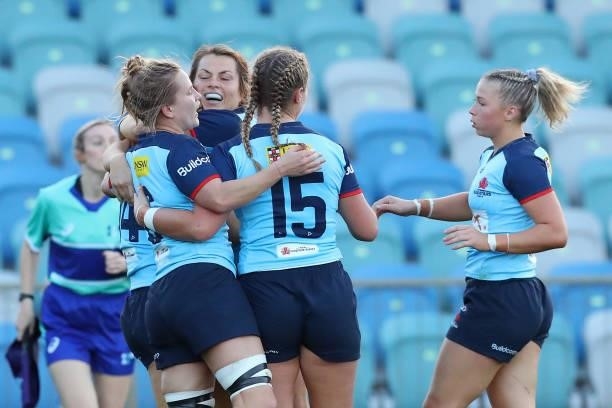 Grace Hamilton of the Waratahs and Arabella McKenzie of the Waratahs celebrate with team mates during the round three Super W match between the NSW...
