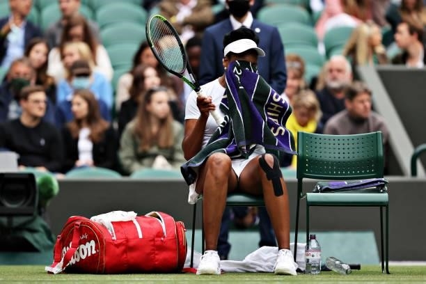 Venus Williams of The United States reacts as she sits down during a change of ends in her Ladies' Singles Second Round match against Ons Jabeur of...