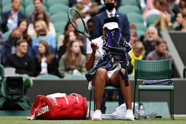 Venus Williams of The United States reacts as she sits down during a change of ends in her Ladies' Singles Second Round match against Ons Jabeur of...