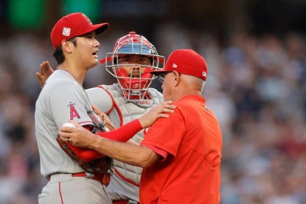 Manager Joe Maddon and Max Stassi meet Shohei Ohtani of the Los Angeles Angels on the mound to take him out of the game during the first inning...