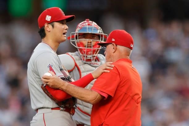 Manager Joe Maddon and Kurt Suzuki meet Shohei Ohtani of the Los Angeles Angels on the mound to take him out of the game during the first inning...