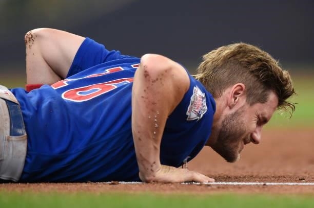 Patrick Wisdom of the Chicago Cubs lays on the field after being injured on a play at first base in the second inning against the Milwaukee Brewers...