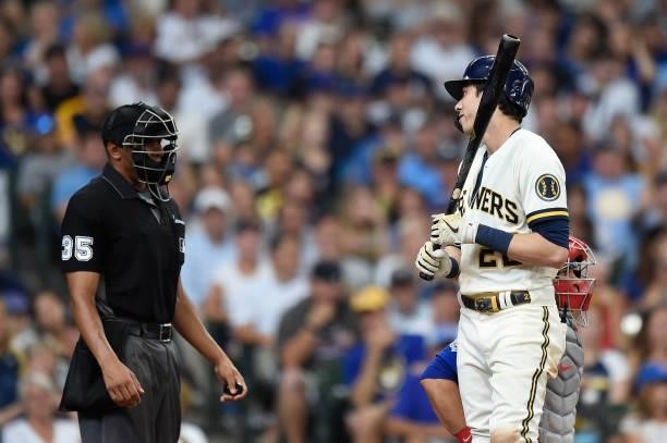 Christian Yelich of the Milwaukee Brewers talks with home plate umpire Jeremie Rehak after a called strike out in the fourth inning against the...