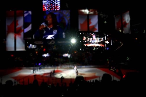 Fan takes a picture with their phone during the Canadian national anthem prior to Game Two of the 2021 NHL Stanley Cup Final between the Tampa Bay...